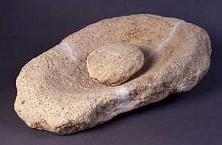 Mano de molino de piedra arenisca, de forma redondeada. Museo de Prehistoria de Valencia
