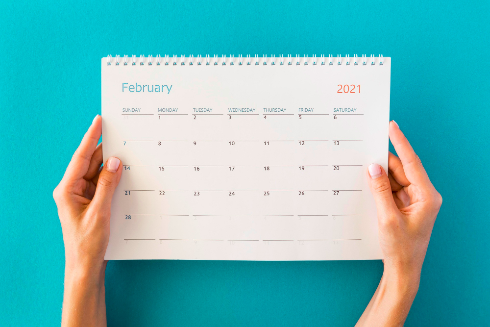 La imagen muestra unas manos sujetando un calendario