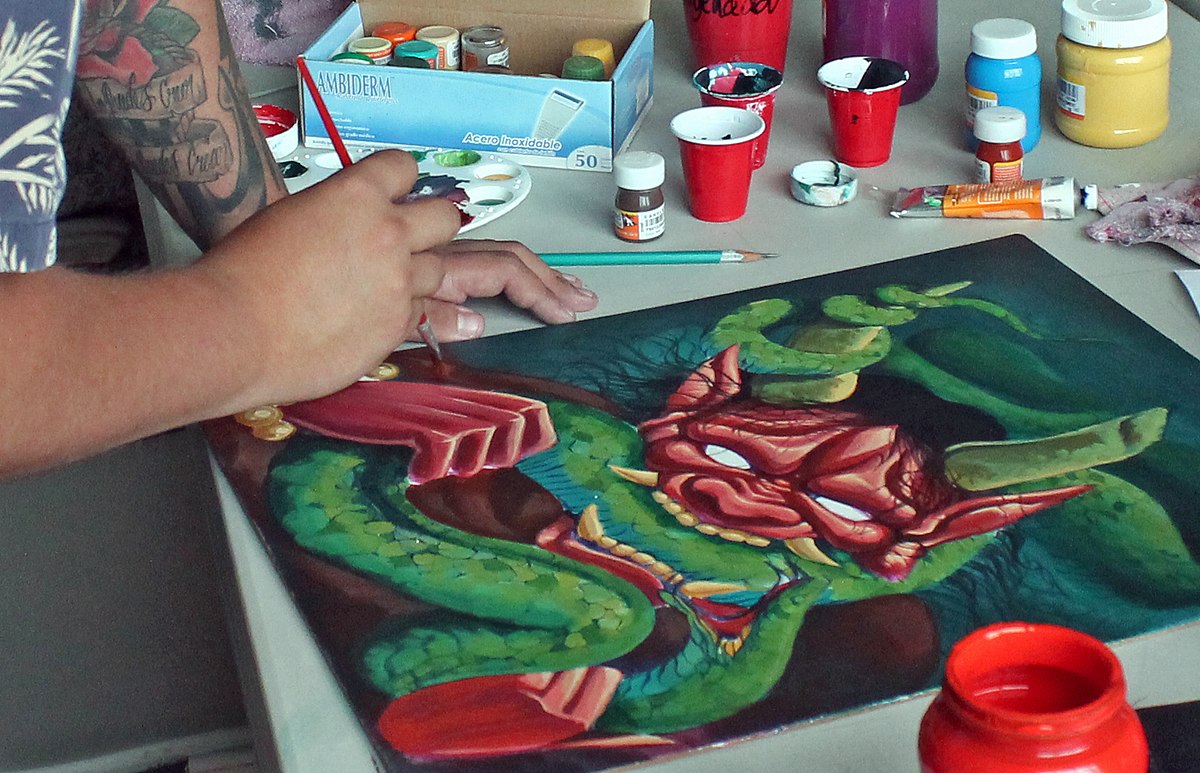 La imagen muestra una persona pintando un cuadro