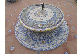 La imagen muestra un reloj de sol decorado con azulejos en el Parque de María Luisa, Sevilla