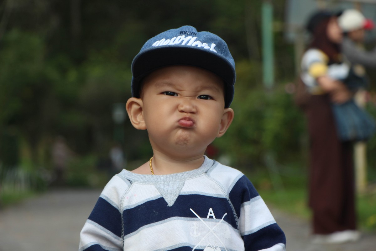 En la imagen puedes ver un niño pequeño con una gorra mostrando un gesto de enfado
