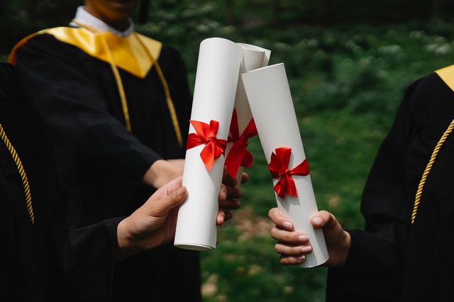 La imagen muestra la entrega de un diploma académico