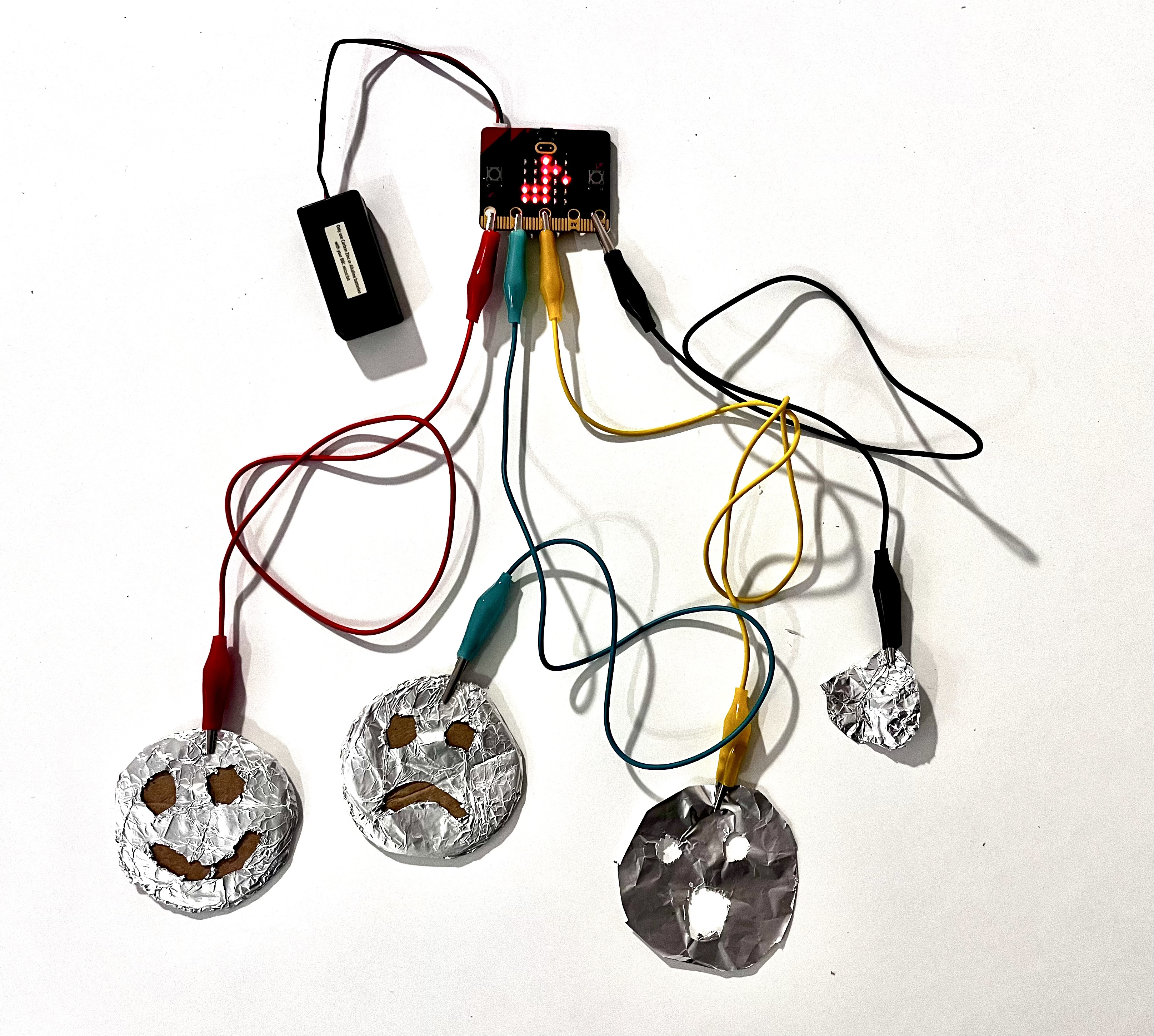 Imagen de circuito de caras de emociones y microbit con los cables enchufados.