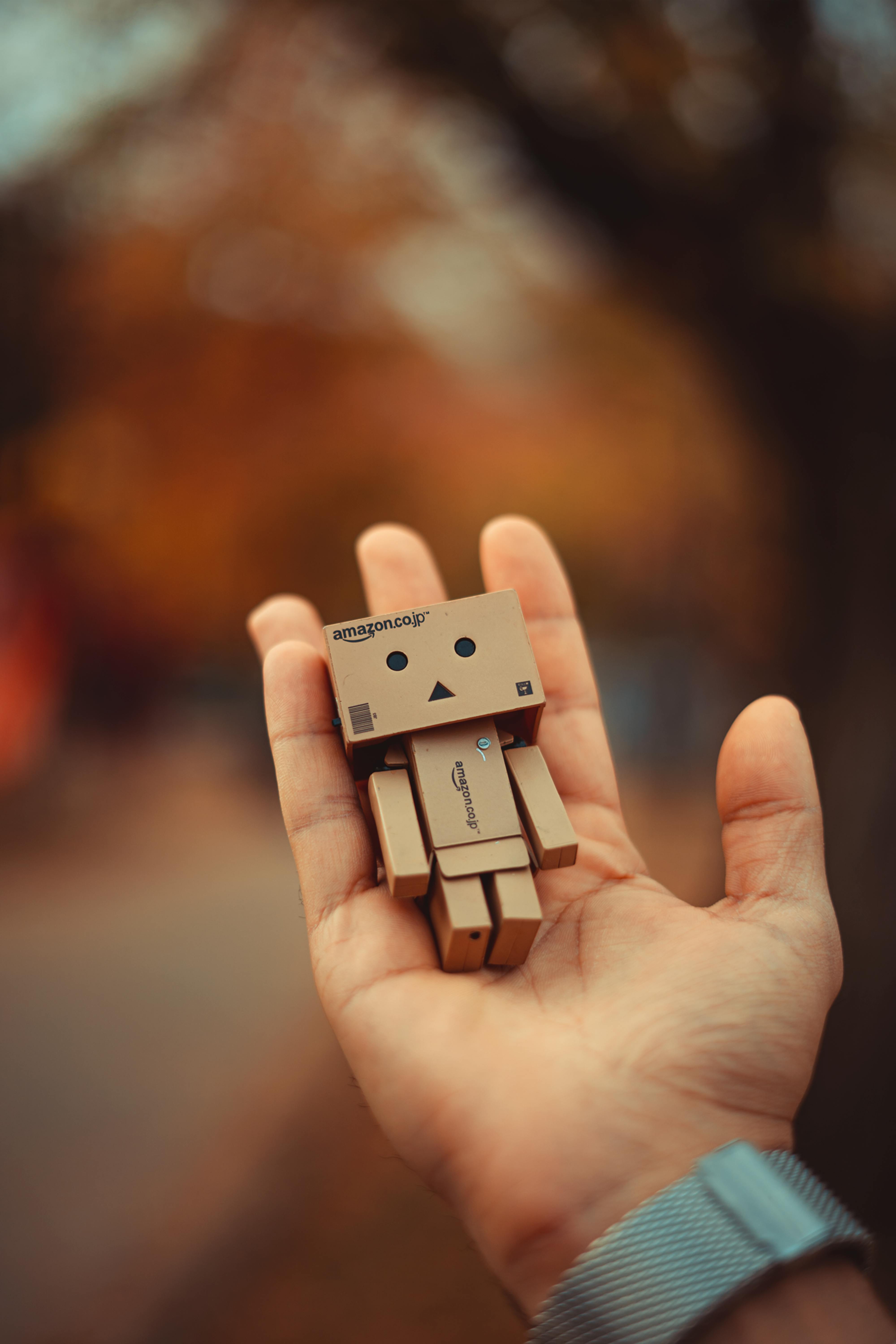 Mano sosteniendo un robot de cartón
