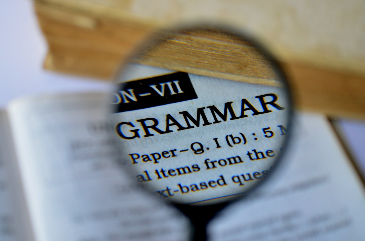 Hoja del diccionario donde está la palabra "grammar" aumentada por una lupa