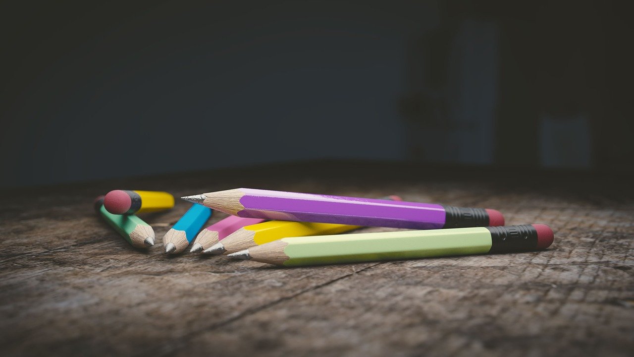 Lápices de colores apilados sobre una mesa