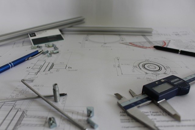 La superficie de una mesa de trabajo llena de dibujos y herramientas de arquitecto.
