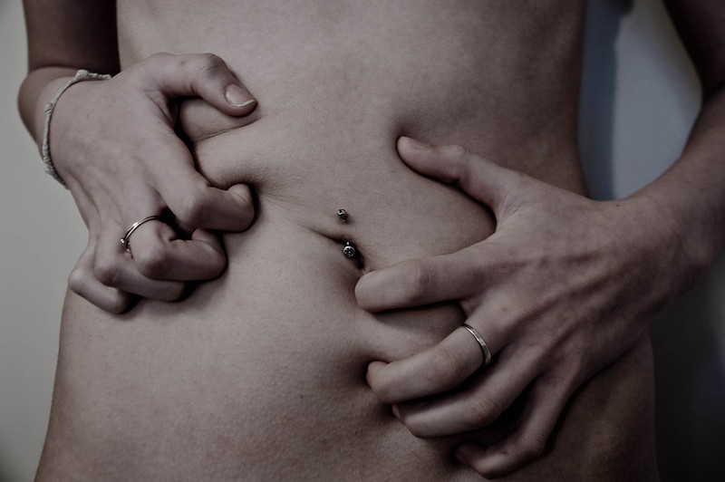 Fotografía de joven agarrándose la barriga